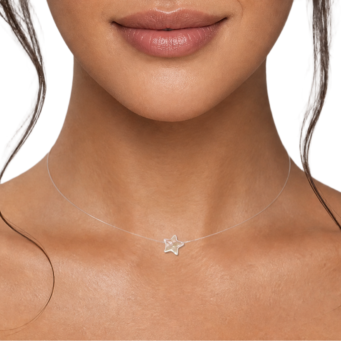 A close-up portrait of a woman with dark hair wearing a delicate clear necklace with a small silver star pearl, set against a solid white background.