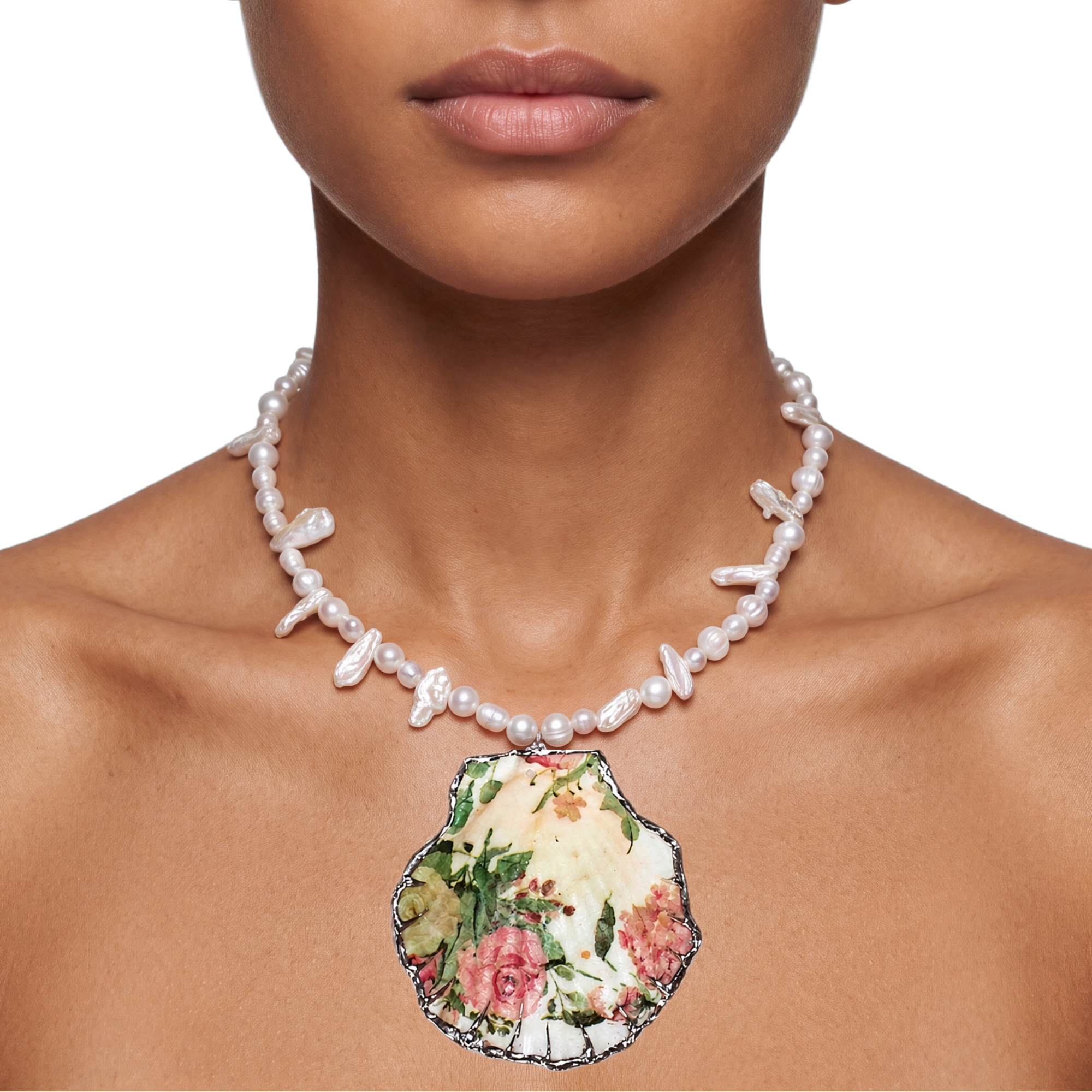 A close-up of a model wearing a pearl necklace with a large scallop shell pendant featuring a vintage floral print.